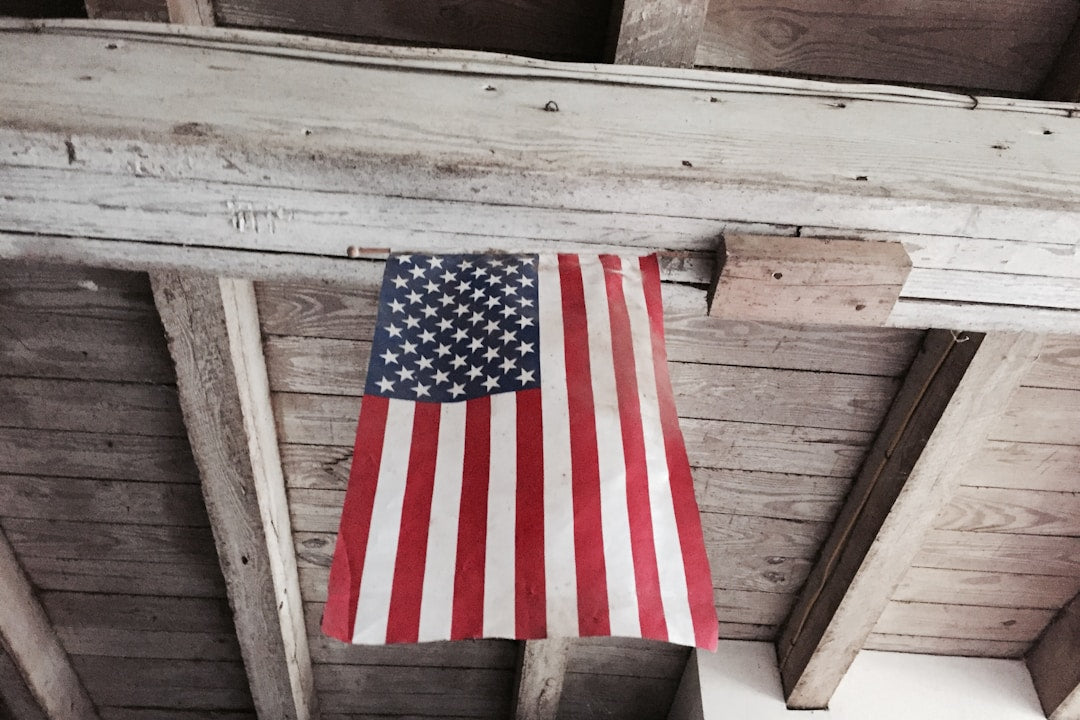 A bag of coffee and a mug on a rustic wooden surface with an American flag in the background.